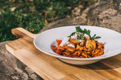 a white bowl of food on a wooden tray at Matild Country Hotel in Nemesvita