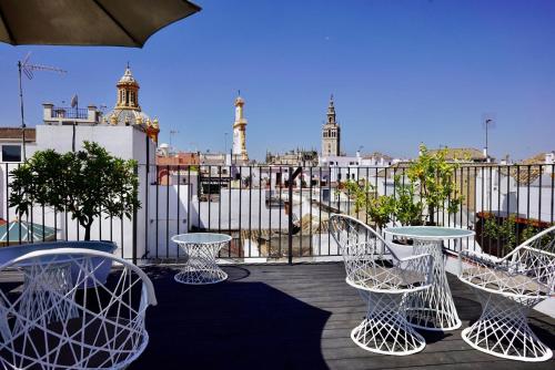 
a patio area with chairs, tables and umbrellas at Hotel Amadeus Sevilla in Seville
