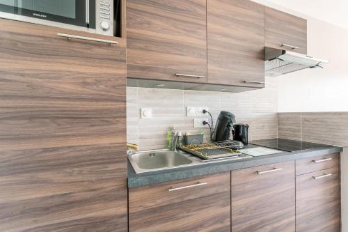 a kitchen with wooden cabinets and a sink at Eolia in Dinard
