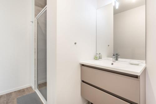 La salle de bains est pourvue d'un lavabo et d'un miroir. dans l'établissement Eolia, à Dinard