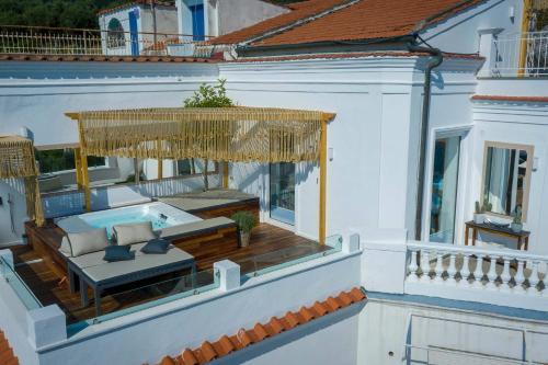 a balcony with a couch and an umbrella on a house at Casa Mariavittoria in Massa Lubrense