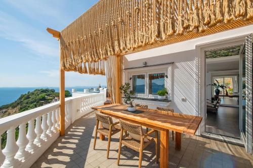 a wooden table on a balcony with a view of the ocean at Casa Mariavittoria in Massa Lubrense