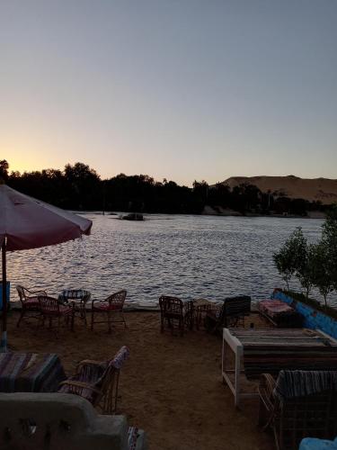 a group of chairs and tables on the shore of a lake at Baba Dool in Aswan