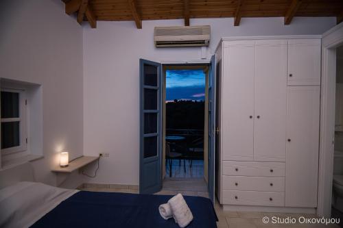 een slaapkamer met een bed en een deur naar een balkon bij Studio Gerani 1 in Porto Cheli