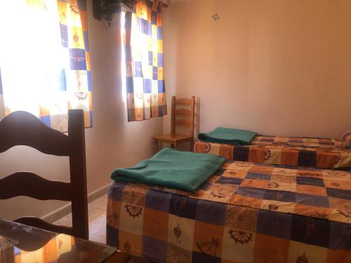 a room with two beds and a chair in it at Hostal ALGECIRAS in Algeciras