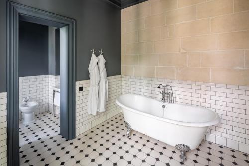 a bathroom with a white tub and a toilet at Lion's Castle Hotel in Lviv