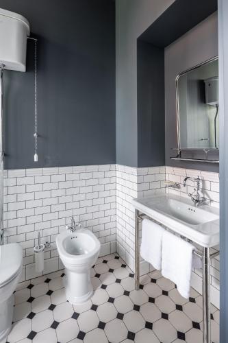 a bathroom with two sinks and a toilet at Lion's Castle Hotel in Lviv
