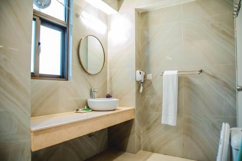 a bathroom with a sink and a mirror at Shelton's Ambassador in Islamabad