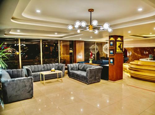 a living room with couches and a chandelier at Shelton's Ambassador in Islamabad