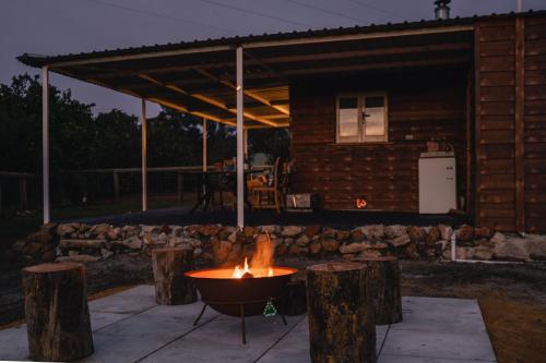 a fire pit in front of a log cabin at Glen Mervyn Lodge in Mumballup