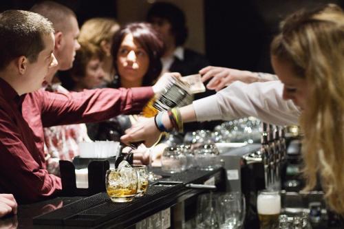 a group of people sitting at a bar preparing drinks at Hard Days Night Hotel in Liverpool