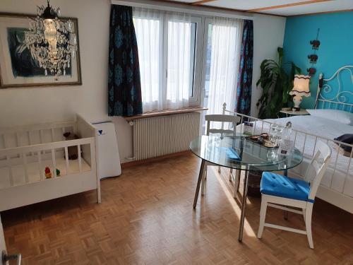 a bedroom with a glass table and a bed at BnB Haus Weibel in Landquart