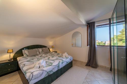 ein Schlafzimmer mit einem Bett und einem großen Fenster in der Unterkunft VILLA Mira in Trogir