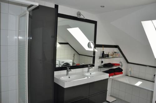 uma casa de banho com um lavatório e um espelho grande em Zweit-Traumwohnung em Marburg an der Lahn