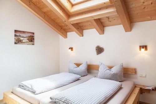 two beds in a room with wooden ceilings at Apartment Ferienhaus Huber in Grainau