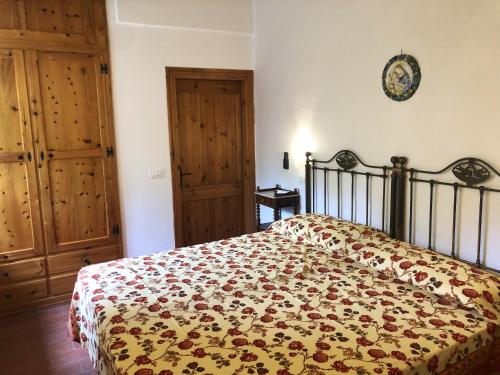 a bedroom with a bed with a comforter on it at Elegant Villa in Tuoro sul Trasimeno with Private Pool in Tuoro sul Trasimeno