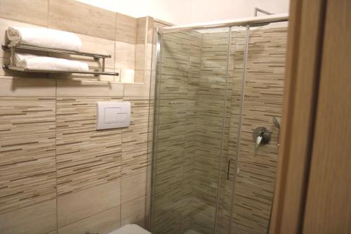a bathroom with a shower with a toilet and towels at Parco Hotel Granaro in Sorbo San Basile