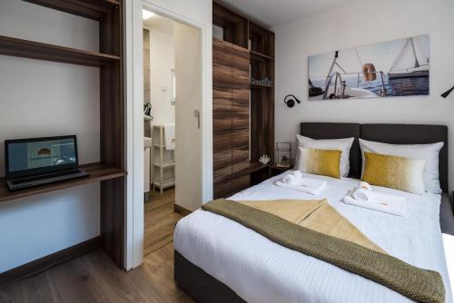 a bedroom with a large bed with a tv on the wall at Mobile Home Vodice 27 in Vodice