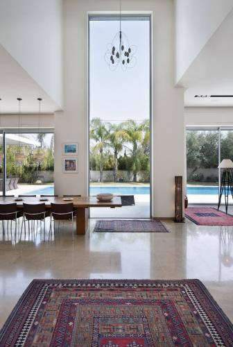 a dining room with a table and a large window at Villa Alice Caesarea in Caesarea