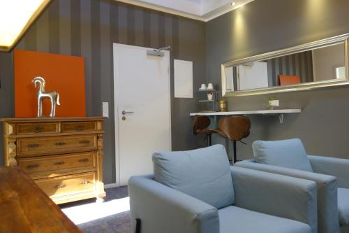 a living room with a blue couch and a dresser at Hotel & Restaurant Venner Moor in Senden