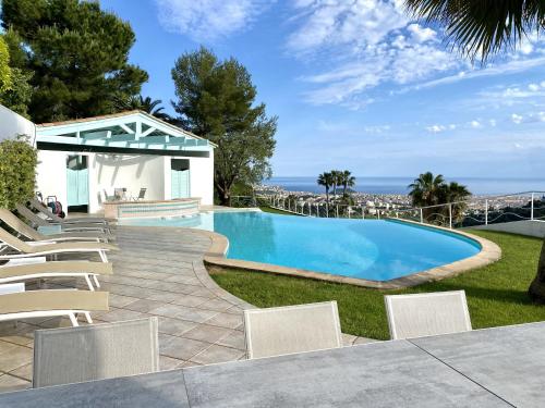 - une piscine dans une cour avec des chaises blanches dans l'établissement VILLA NICE-GAIRAUT by RIVIERA HOLIDAY HOMES, à Nice