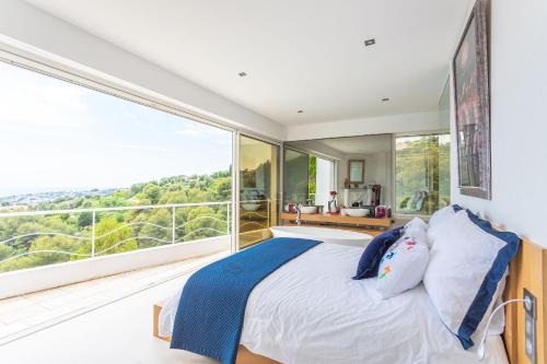 une chambre avec un lit et une grande fenêtre dans l'établissement VILLA NICE-GAIRAUT by RIVIERA HOLIDAY HOMES, à Nice