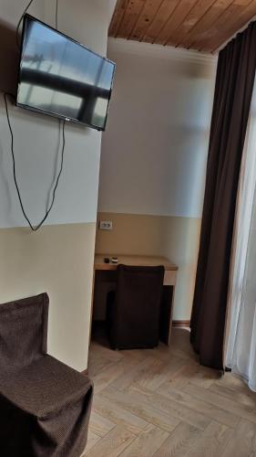 a room with a desk and a tv on the wall at Dom Fedorovyh in Sergeyevka