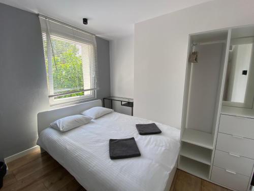 um quarto com uma cama branca com duas toalhas em Hostel 19 Sopot em Sopot