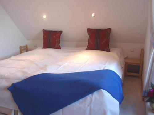 UlsnisにあるFerienwohnung-Gluecksburgのベッドルーム1室(赤と青のシーツが備わるベッド2台付)