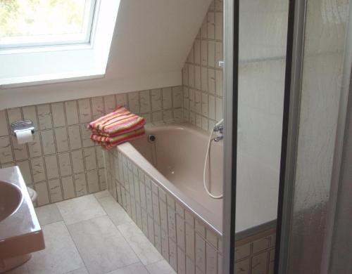 a bathroom with a bath tub and a sink at Ferienwohnung-Gluecksburg in Ulsnis