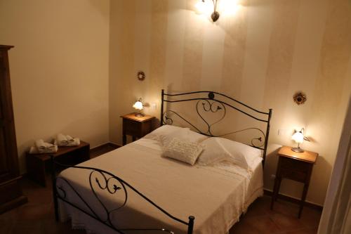 a bedroom with a bed with two lamps on two tables at B&B Le Foglie D'Argento in Caltabellotta