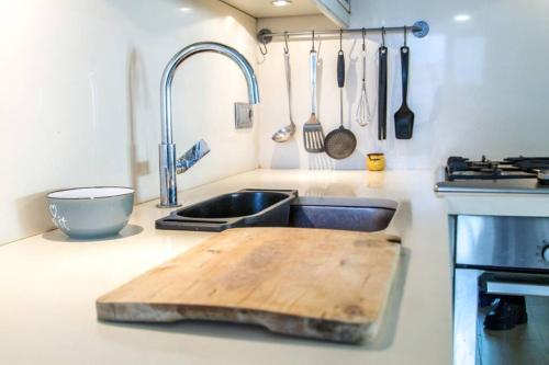 a kitchen with a sink and a wooden cutting board at Primera linea de mar. Apartamento turístico Salou in Salou
