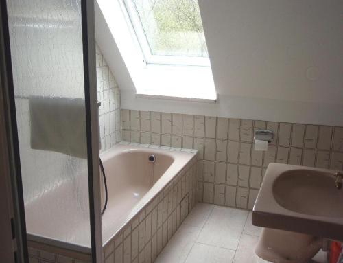 a bathroom with a bath tub and a window at Ferienwohnung-Gottorf in Ulsnis