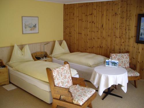 Zimmer mit 2 Betten, einem Tisch und Stühlen in der Unterkunft Kur- und Gästehaus Villa Anna in Bad Hofgastein