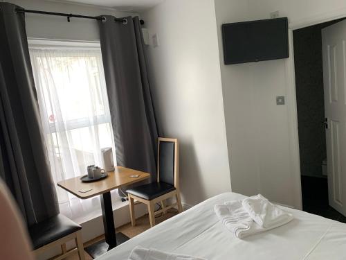 a bedroom with a bed and a table and a window at The Royal Clarence Hotel (on the Seafront) in Burnham on Sea