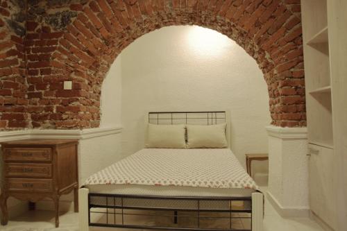 a bed in a room with a brick wall at Top Center Semi-detached Apartment Studio in Sofia