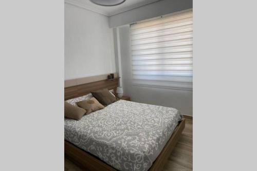 a bedroom with a bed and a window with blinds at Precioso apartamento en Benicasim in Benicàssim