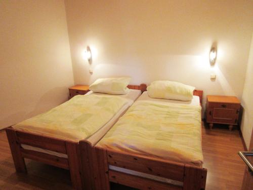 two twin beds in a room with two night stands at Petersimmerhof in Taching am See