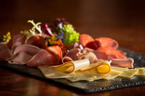 a plate of meats and cheese on a table at Hotel Wellness Goldenes Fass Meißen in Meißen