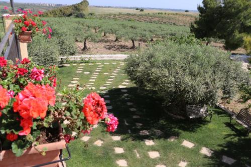 a view of a garden with flowers and trees at B&B Le Foglie D'Argento in Caltabellotta
