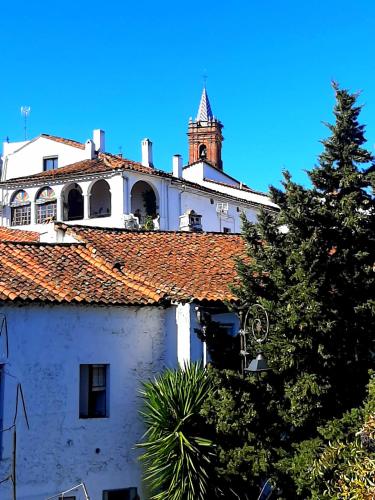 a building with a clock tower on top of it at Alojamiento La Fuente in Fuenteheridos