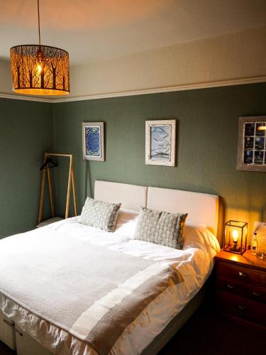 a bedroom with a large white bed with two pillows at The Tors in Okehampton