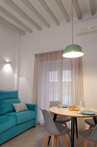 a living room with a blue couch and a table at ABAL Apartments - Barrio in Alicante
