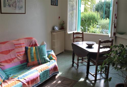 ein Wohnzimmer mit einem Sofa, einem Tisch und einem Fenster in der Unterkunft Ta Maria in Céret
