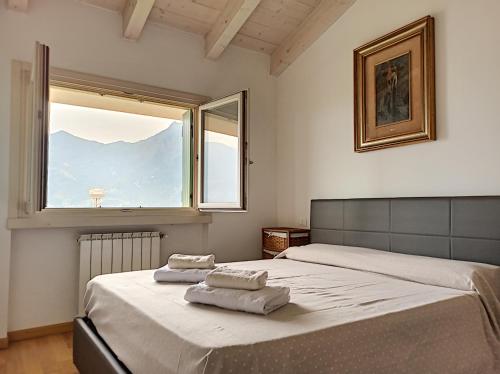 Un dormitorio con dos camas y una ventana. en Feel at Home - CASA SOFIA, en Lovere
