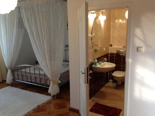 a bathroom with a sink and a bed and a bathroom door at Willa Puńsk z basenem nad jeziorem in Puńsk