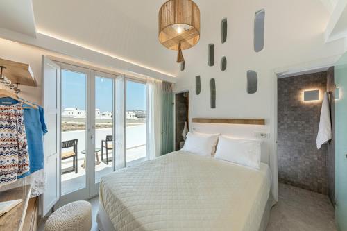 Alafropetra Luxury Suites في أكروتيري: غرفة نوم بسرير وشرفة
