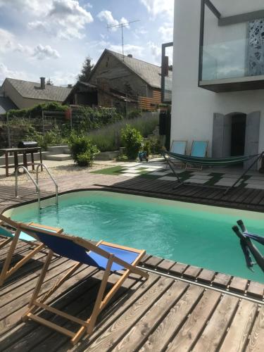 a swimming pool with a chaise lounging chair and a swimming pool at ZiMo Taliándörögdi MoZiHáz in Taliándörögd