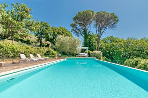 an empty swimming pool with chairs and trees at Agriturismo La Macinara in Ponte Pattoli