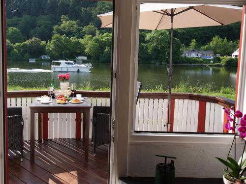 a porch with a table and a view of a boat at Altes Fährhaus an der Mosel anno1633 in Traben-Trarbach